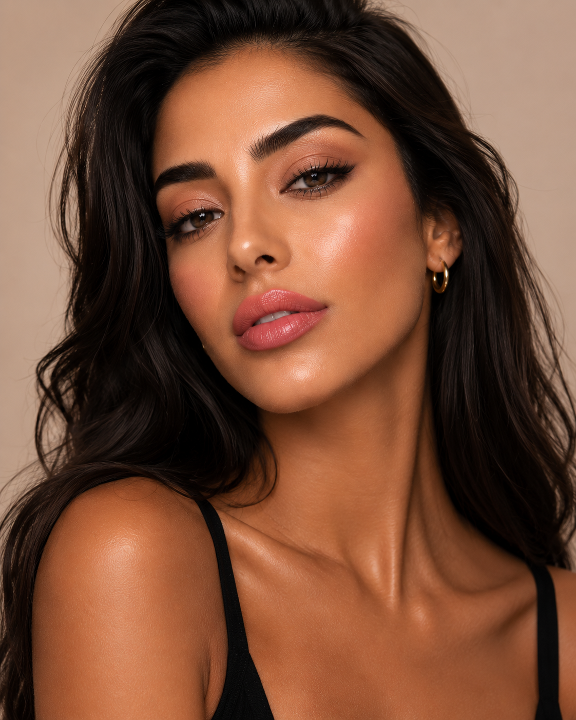 Bruette model wearing KDLR Beauty Labs Noir Patent Cream Lipstick in Darling Dahlia with luminous skin and soft peachy pink satin lips.