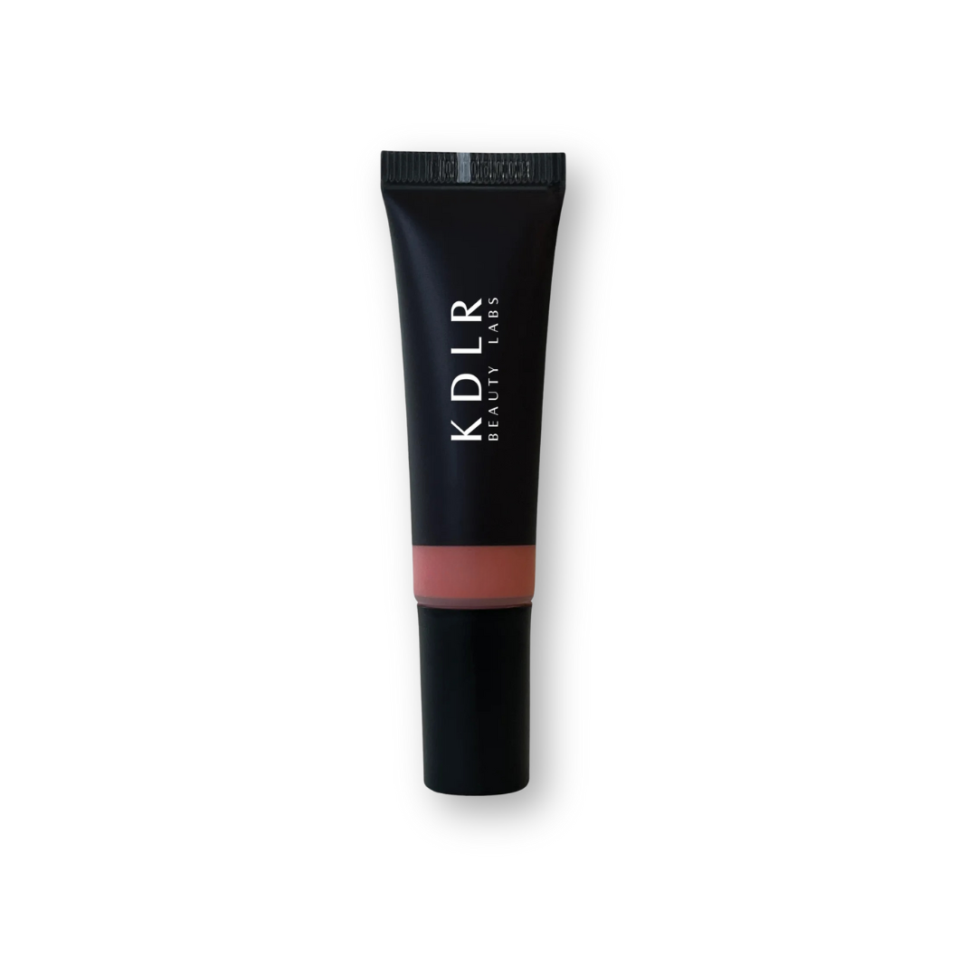 KDLR Beauty Labs Liquid Blush bottle, showcasing its vegan and cruelty-free label, with drops demonstrating its blendable and buildable formula for all skin types. Variant: Dew Peach