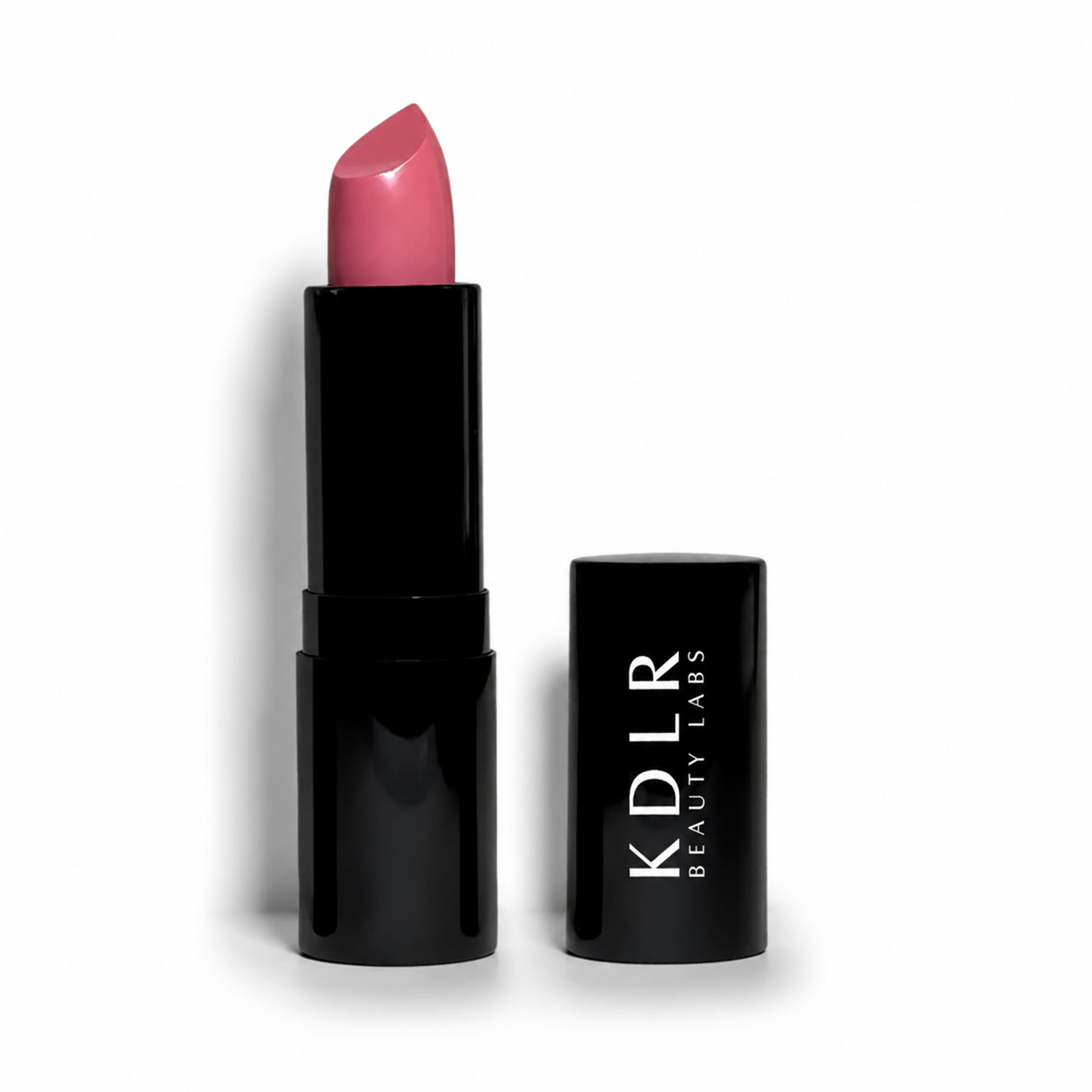 KDLR Beauty Labs Noir Patent Cream Lipstick in Parisian Pink, a soft pink satin lipstick in glossy black packaging on a white studio background.