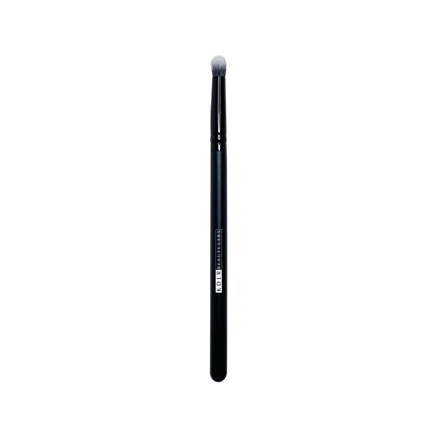 KDLR Beauty Labs Precision Crease and Smudge brush, a small tapered synthetic eyeshadow blending and eyeliner smudging brush with black and white bristles and a glossy black handle on a white background.